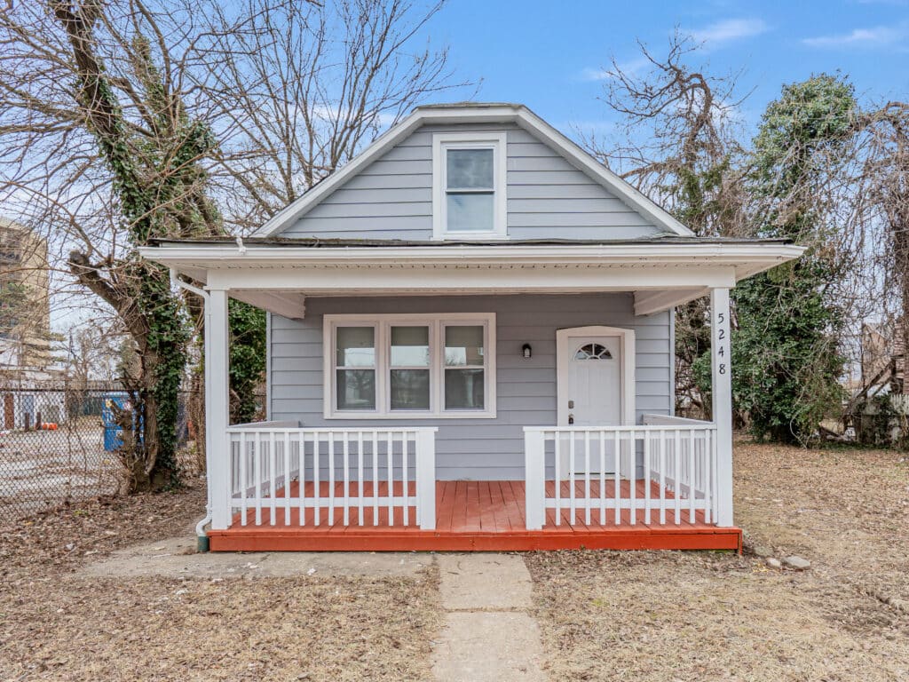 Front view of 5248 Cordelia Avenue, a renovated gray bungalow with white trim and a covered front porch in Baltimore’s Arlington neighborhood.