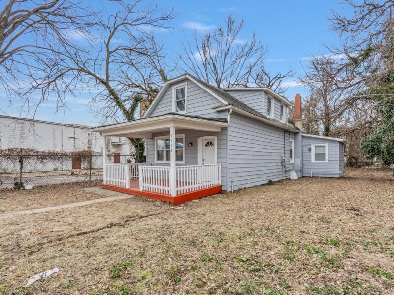Angled exterior view of 5248 Cordelia Avenue, a renovated bungalow with wraparound yard and covered front porch.