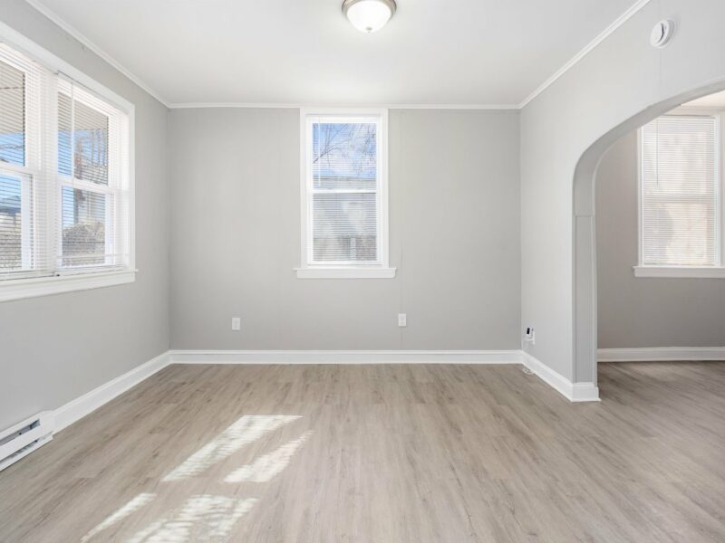 Living room at 5248 Cordelia Avenue with luxury vinyl plank flooring, large windows, and arched doorway.