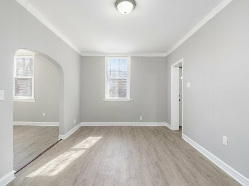 Dining room at 5248 Cordelia Avenue with vinyl plank flooring, gray walls, and natural light from two windows.