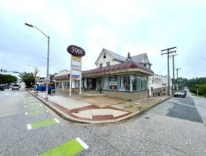 Corner view of commercial building at 5001-5003 Harford Road with red awnings and pole signage.