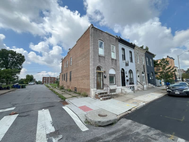 Corner view of 2307 E. Preston Street, an end-of-group brick townhome in Broadway East