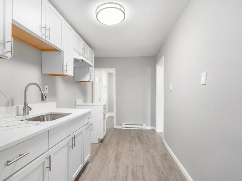 Kitchen at 5248 Cordelia Avenue featuring white cabinets, stainless steel faucet, and luxury vinyl plank flooring.