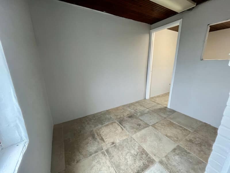 Second-floor rear room with neutral tile flooring and partial wall openings at 5839 Belair Road.