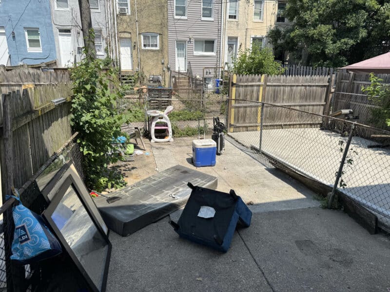 Fenced rear yard at 1346 Carroll Street with concrete patio and alley access.