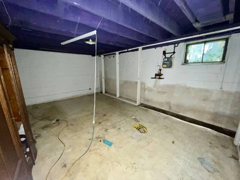 Unfinished basement with painted exposed ceiling joists and concrete floors at 5501 W. Forest Park Avenue.