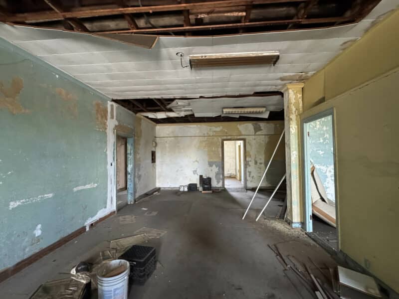 Expansive upper-level room with open layout, exposed ceiling, and renovation materials.