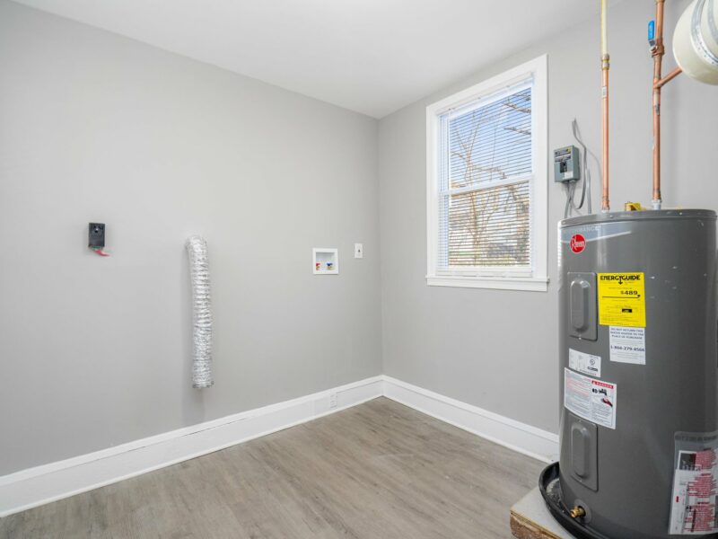Laundry and utility room at 5248 Cordelia Avenue with water heater, washer/dryer hookups, and luxury vinyl plank flooring.