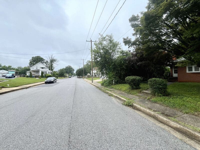 Street view of Winthrope Avenue in Baltimore’s Hamilton neighborhood, showing single-family homes, parked cars, and overhead utility lines.