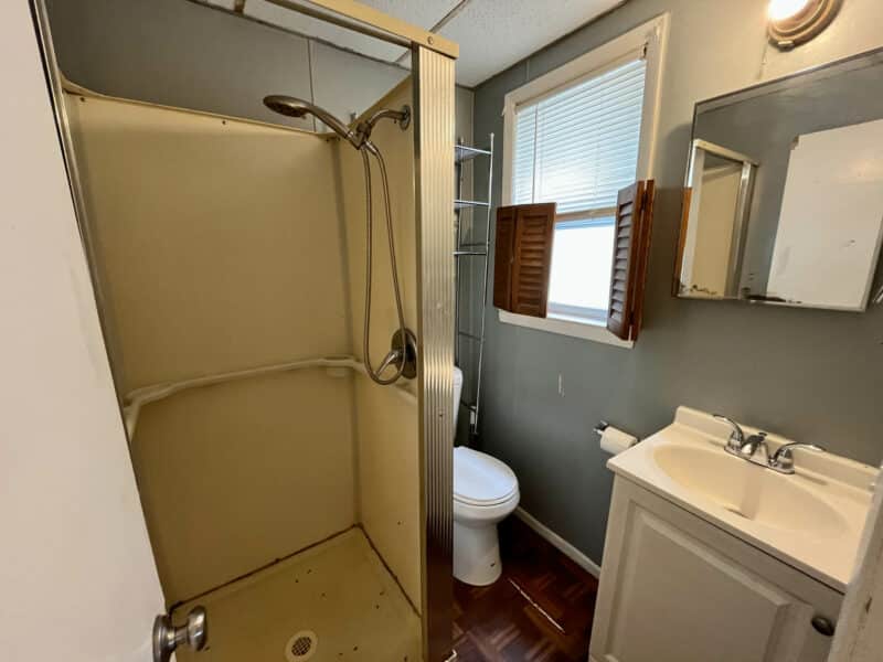 Compact bathroom in Apartment 3 at 4831 Belair Road featuring stall shower, single-vanity sink and window for natural light.