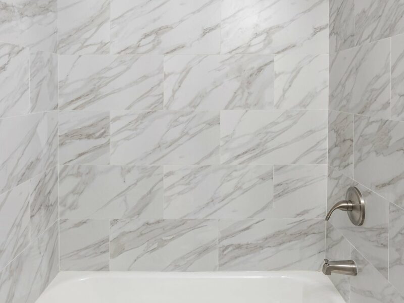 Close-up of marble-look tile tub surround in updated bathroom at 5248 Cordelia Avenue.