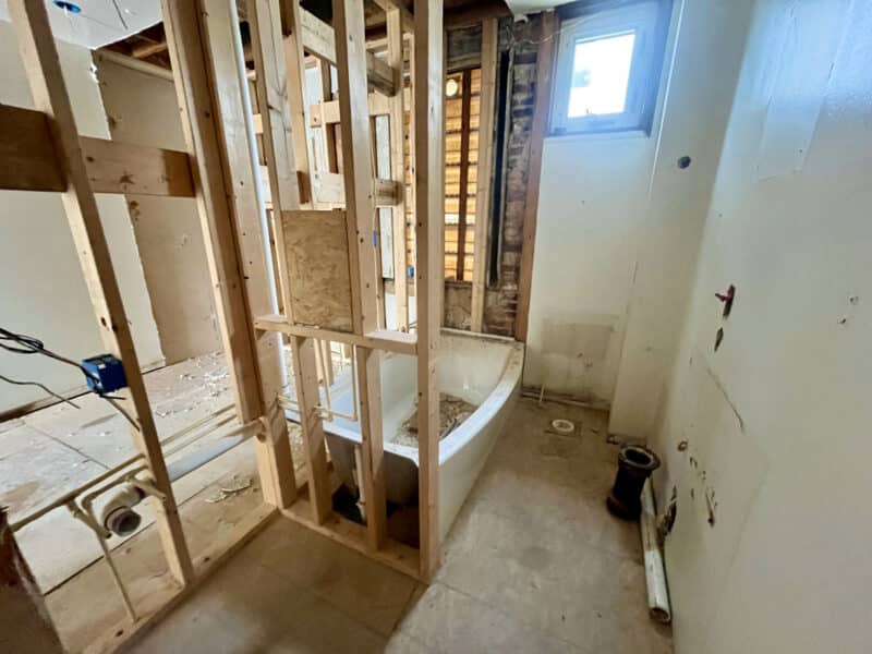 Partially framed bathroom with bathtub installation and exposed plumbing
