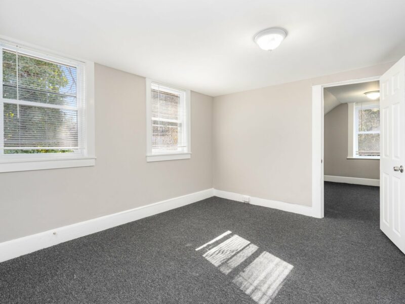 First-floor bedroom with carpet flooring and double windows at 5248 Cordelia Avenue in Baltimore City.