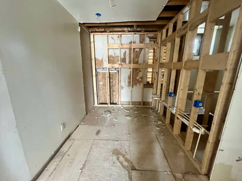Gutted interior room with exposed wall framing and electrical wiring