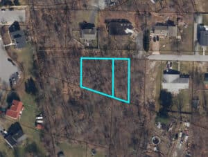 Aerial view of two adjacent unimproved residential lots outlined in blue on Valley Forge Road in Randallstown, Maryland.
