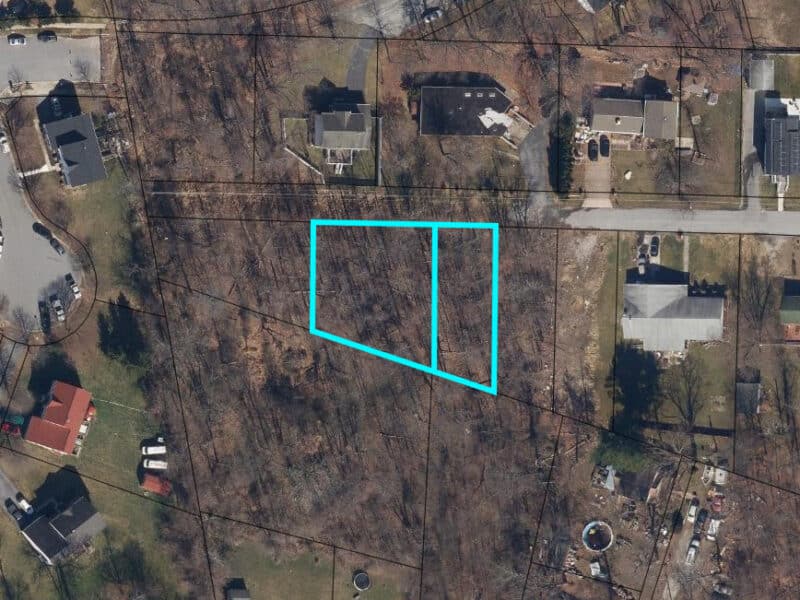 Aerial view of two adjacent unimproved residential lots outlined in blue on Valley Forge Road in Randallstown, Maryland.