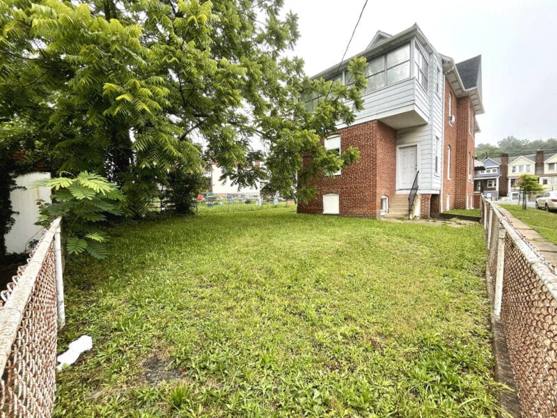 Grassy rear yard enclosed by chain-link fencing at 5839 Belair Road.