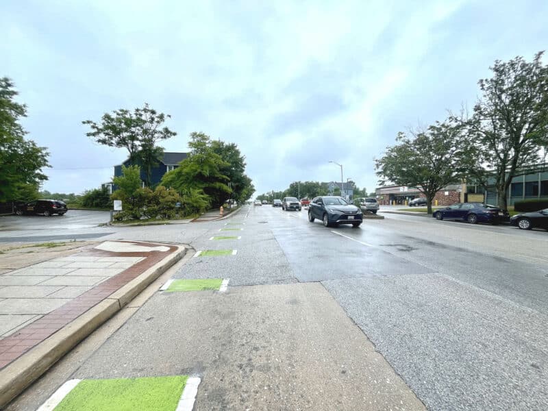 Street-level view looking south along Harford Road with active traffic, sidewalks, and landscaped medians.