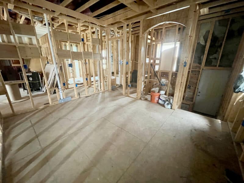 Large unfinished interior space with framed walls and partial ceiling work