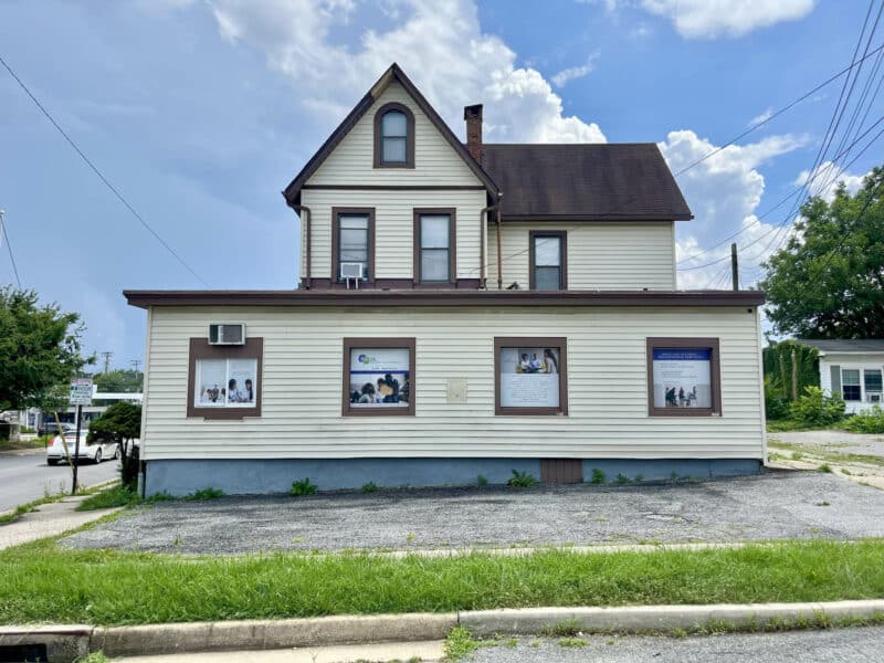 Side view of two-story commercial office building with driveway and paved lot in Homeland, Baltimore