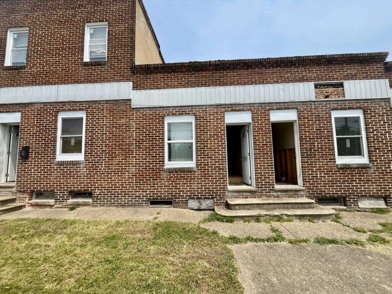 Brick multifamily building with two levels on one end and separate entry doors on the ground level