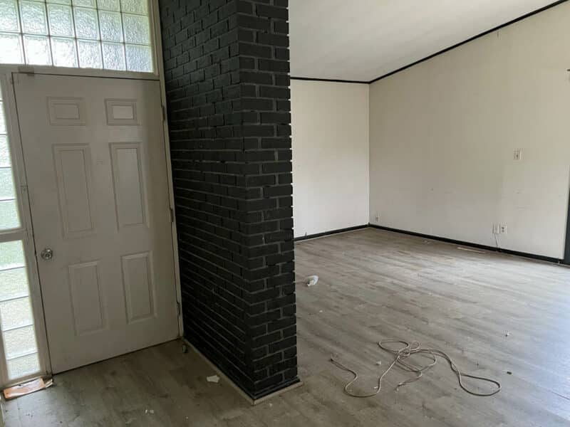 Interior view of entryway at 4761 Bonnie Brae Road featuring a dark brick column, light flooring, and door with glass block window.