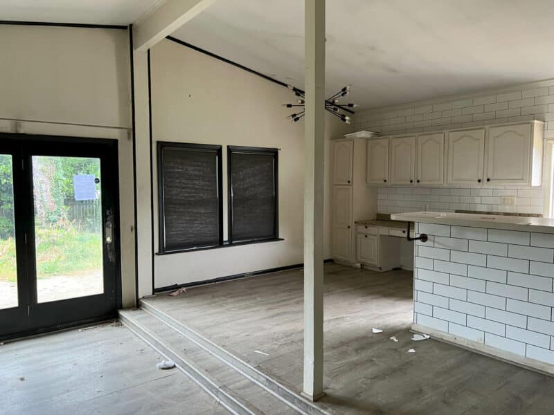 Open-concept living area at 4761 Bonnie Brae Road with sliding glass doors, sloped ceiling, and white kitchen cabinetry.