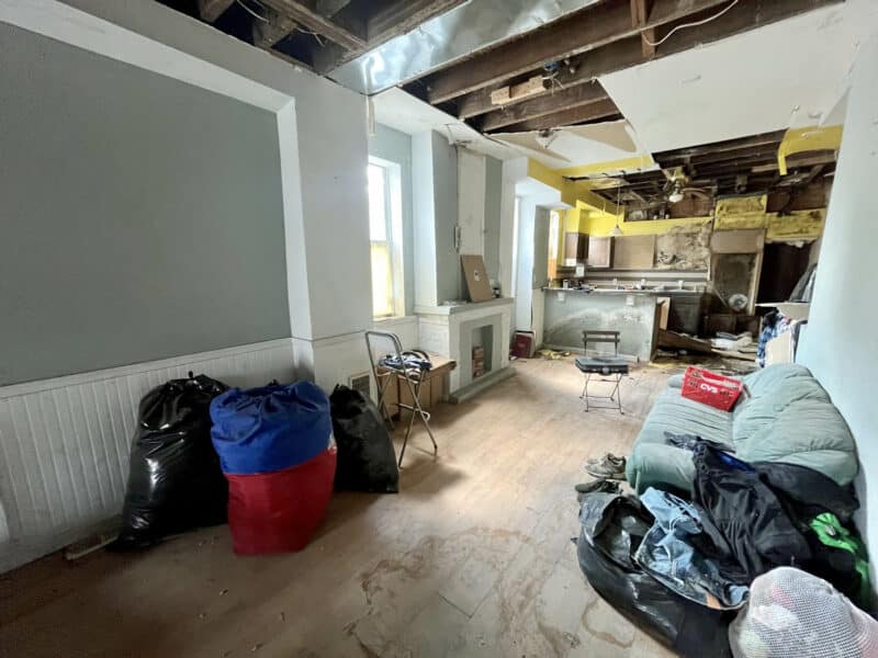 Dining room at 2307 E. Preston Street with exposed ceiling, unfinished walls, and scattered debris.