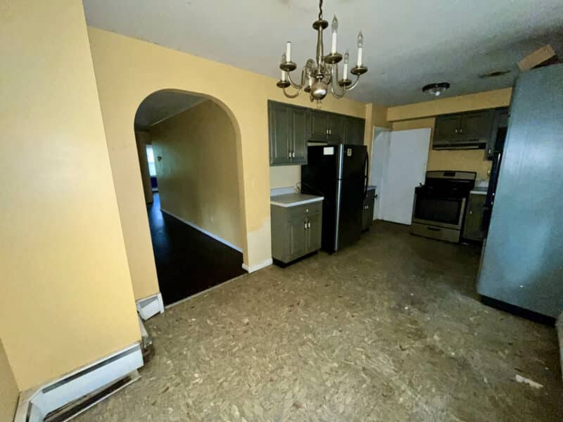 Eat-in kitchen at 5900 Winthrope Avenue with vinyl flooring, chandelier, and wood cabinetry.