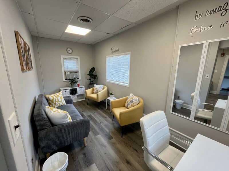 Furnished office space with couch, chairs, and desk in front unit of 5839 Belair Road.