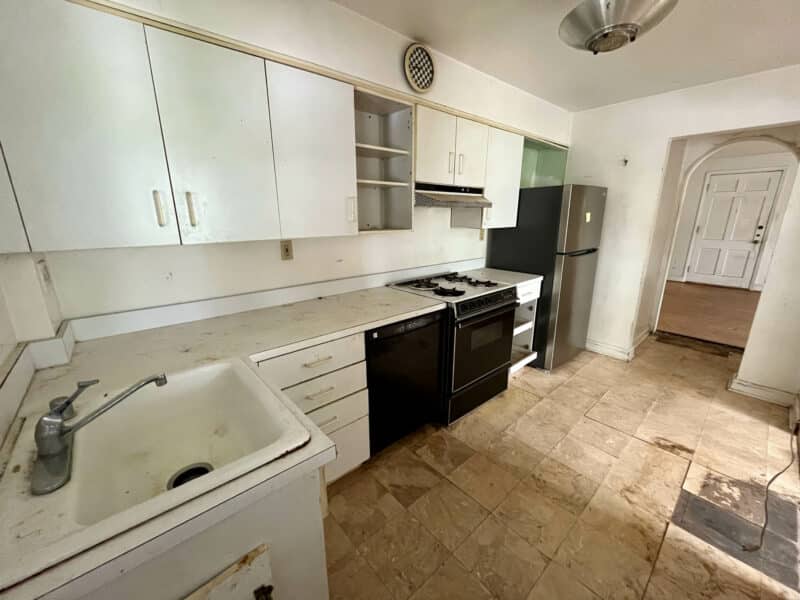 Galley-style kitchen with white cabinetry and gas range at 5501 W. Forest Park Avenue.