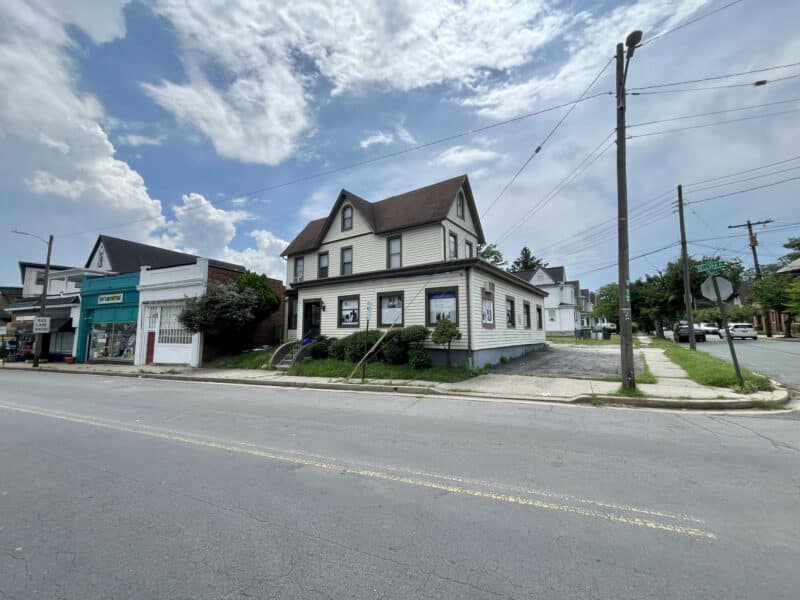 Corner view of two-story office building at 5706 Bellona Avenue with adjacent storefront and surrounding street
