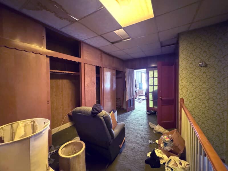 Potential third bedroom at 3412 Esther Place with walk-through layout, wood paneling, and renovation opportunity.