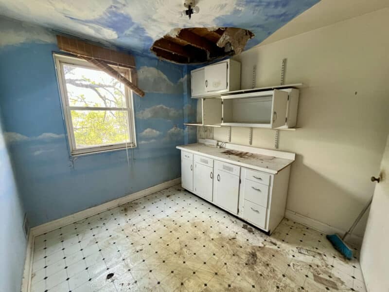 Bedroom with sky-themed mural and white cabinets at 5501 W. Forest Park Avenue.