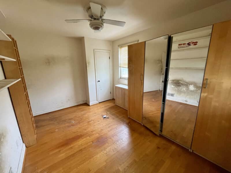Second bedroom with hardwood flooring, ceiling fan, and built-in mirrored wardrobes at 5501 W. Forest Park Avenue.