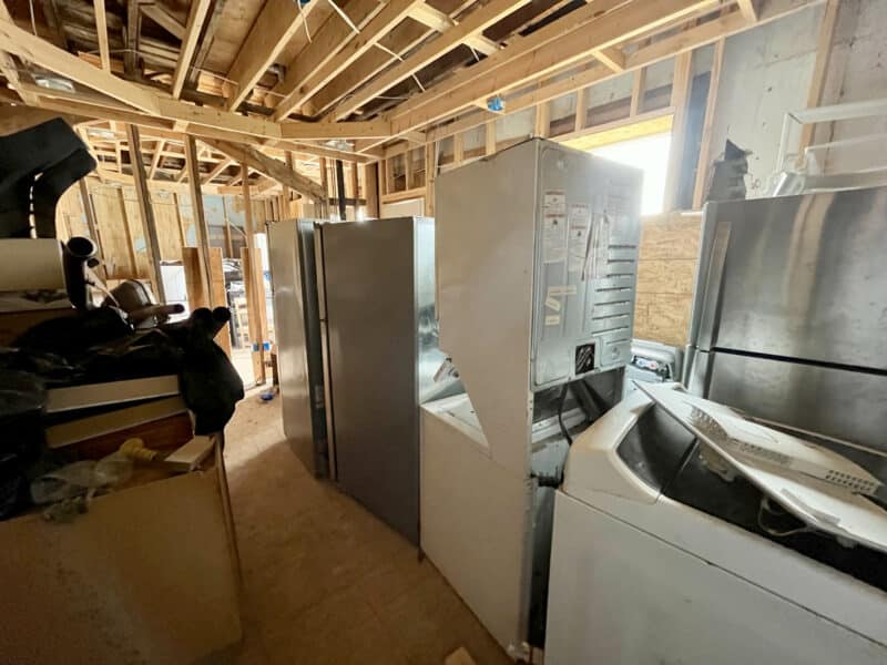 Framed apartment interior with scattered appliances and open ceiling joists at 539-549 45th Street