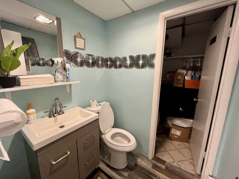 Bathroom inside second commercial unit at 4831 Belair Road with vanity, toilet, and access to utility/storage room.