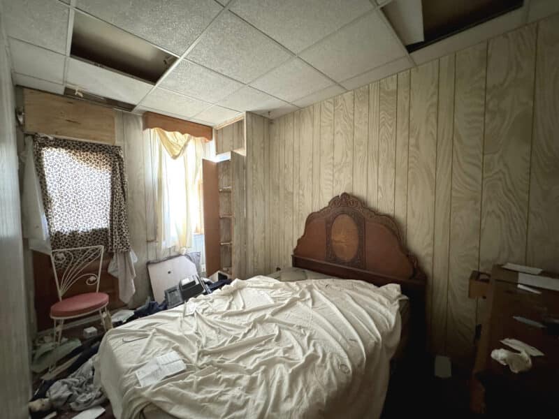 Second bedroom at 3412 Esther Place featuring paneled walls, drop ceiling, and natural light through front-facing windows.