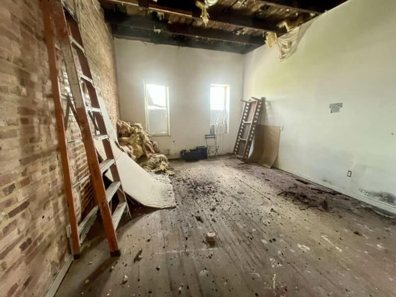 Bedroom at 2307 E. Preston Street with exposed ceiling and debris-covered floor