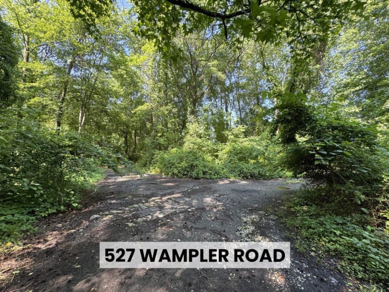 Gravel and asphalt clearing surrounded by dense woodland on the Middle River residential development site