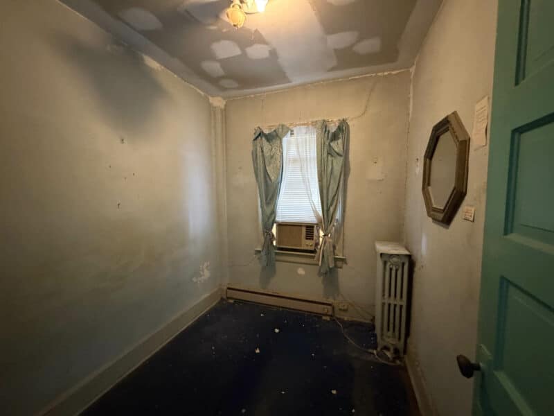 Small bonus room with window, radiator, and blue carpeting on the second floor of 909 Jackson Street NE.