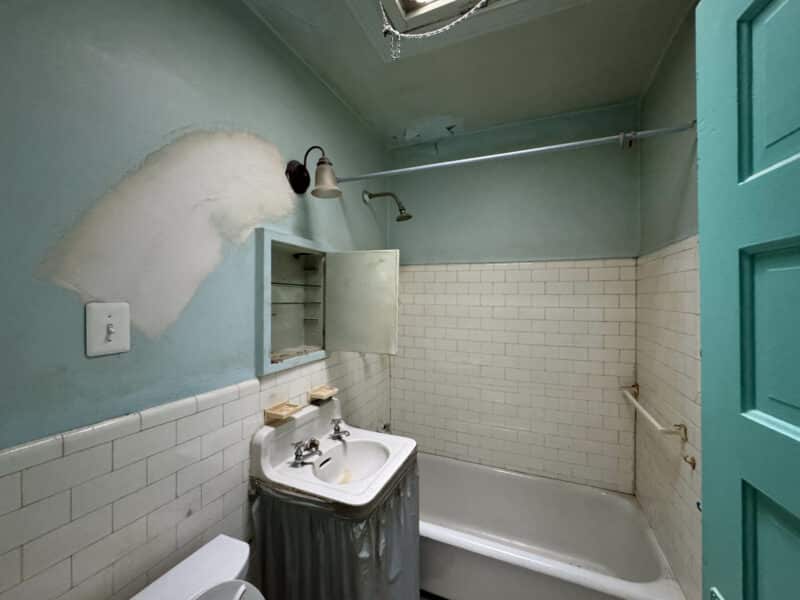 Bathroom with tub-shower combo, pedestal sink, and white subway tile at 909 Jackson Street NE.