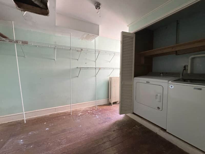 Laundry room with washer, dryer, utility sink, and storage cabinets.
