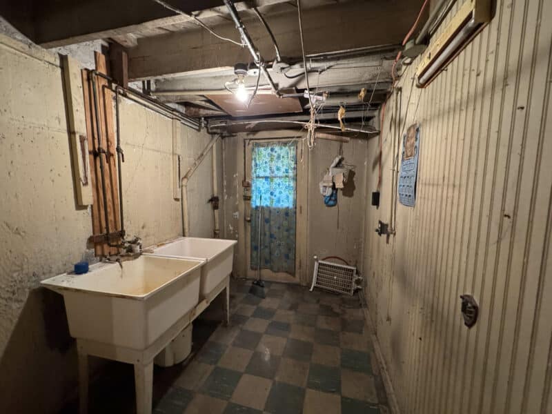 Basement utility room with double laundry sink and exposed ceiling at 909 Jackson Street NE.