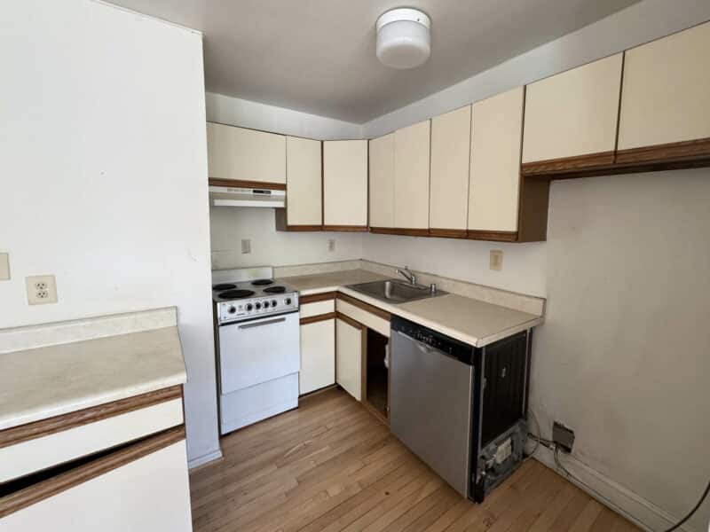 Compact kitchenette with white cabinetry, electric stove, and dishwasher in potential ADU.