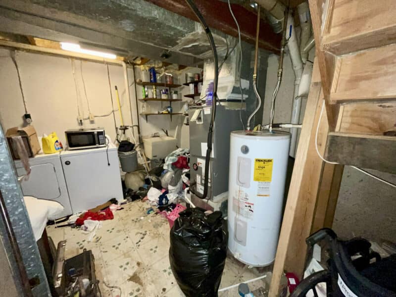 Basement laundry and utility room with washer and dryer, water heater, exposed ceiling, and shelving at 12366 Bonfire Drive.