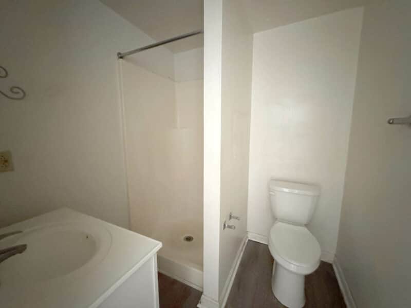 Simple bathroom with shower stall, toilet, and vanity in potential ADU.