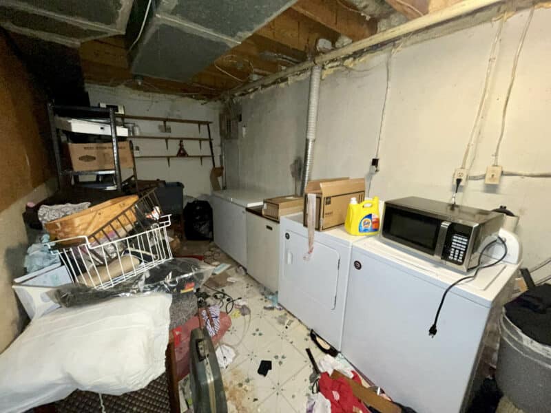Basement laundry area with built-in cabinets, countertop, and cluttered floor at 12366 Bonfire Drive.