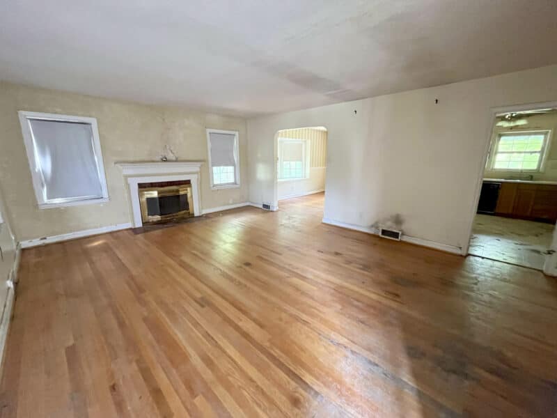 Spacious living room with hardwood floors, fireplace, and multiple windows allowing natural light.