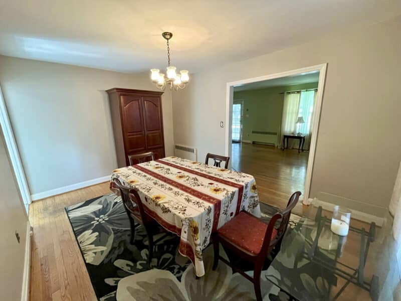 Formal dining room with hardwood floors, chandelier, and doorway to living area at 19 Dunmore Road.